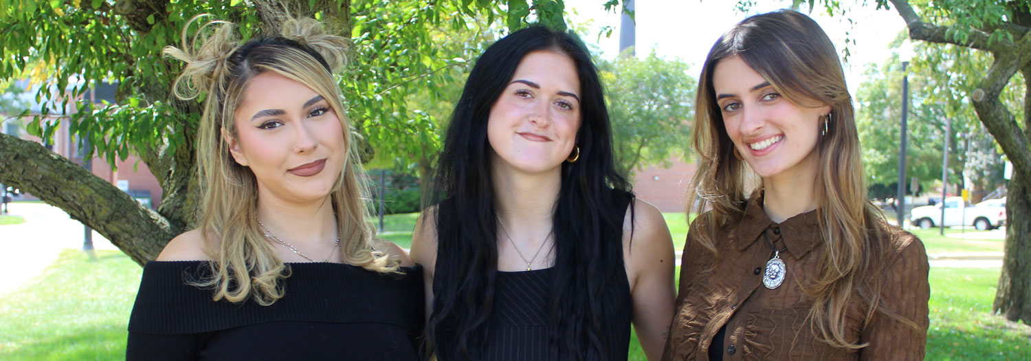 Group of three smiling female students posing for a photo