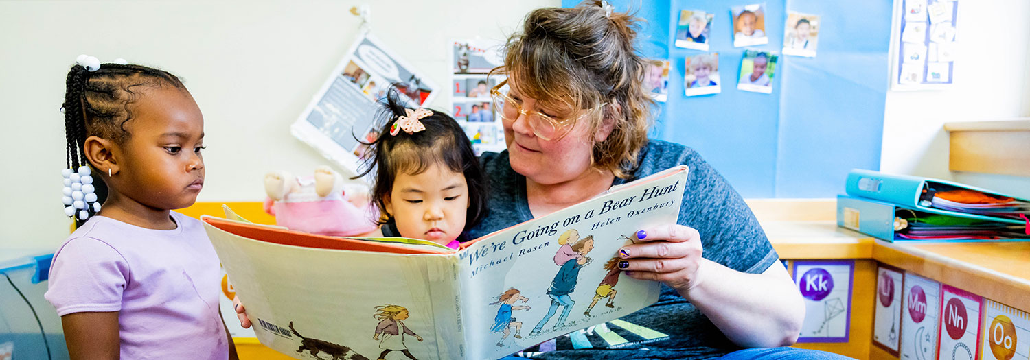 A teacher reads a book to children at the Child Development and Family Center