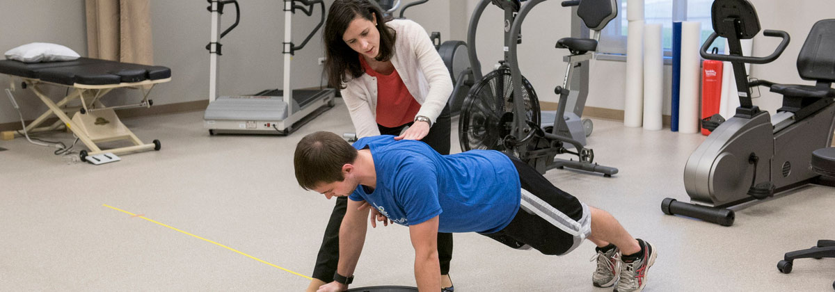 Professor and student demonstrate physical therapy activity